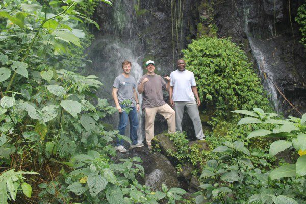 Aris, Ben, and Greg at Mount Cameroon in lush greenery in front of a waterfall